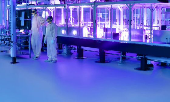 两名身穿防护服的员工在研究激光器内